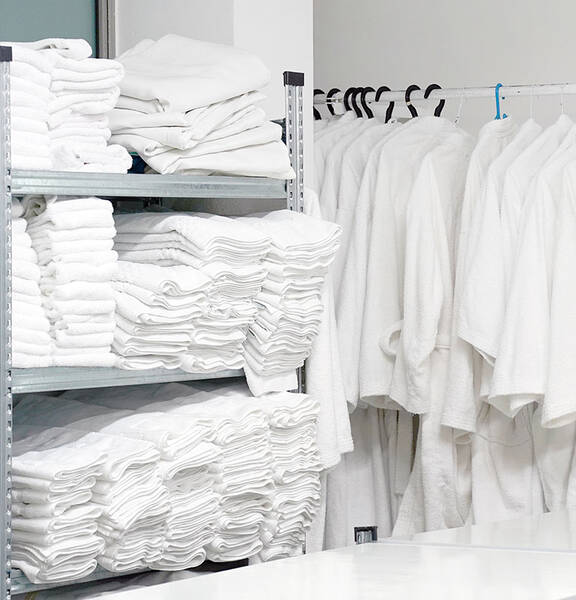 A stockroom full of hanged robes and folded towels